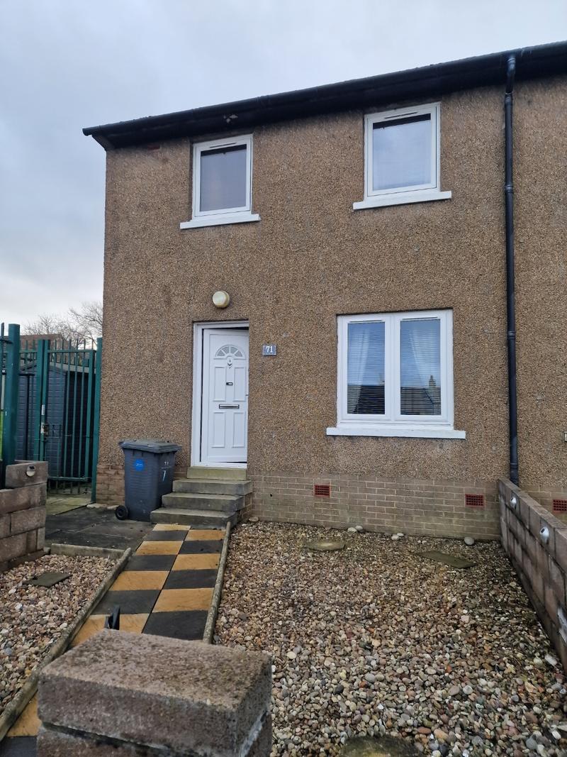 End-terrace house with tired brown pebbledash before work