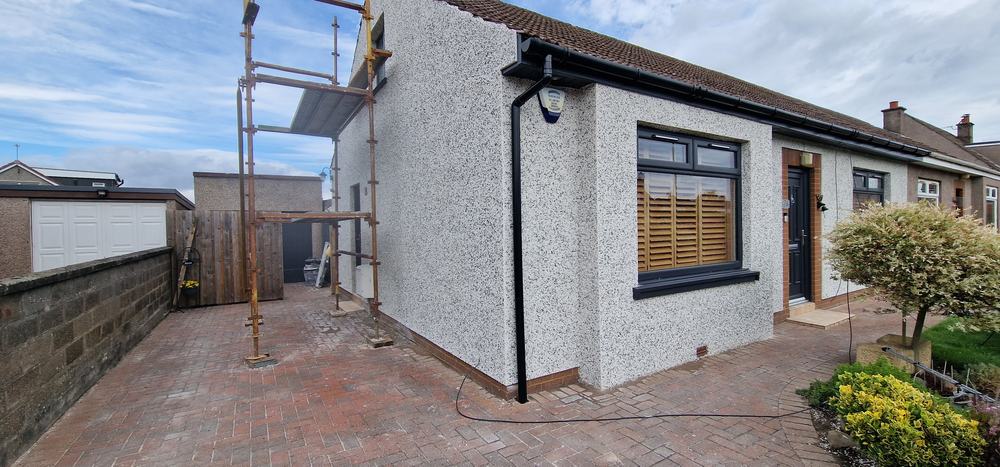 Bungalow in new white dry dash with a black roofline