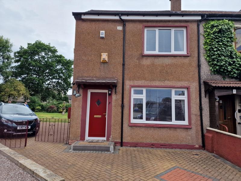 House front in dated brown pebbledash before work