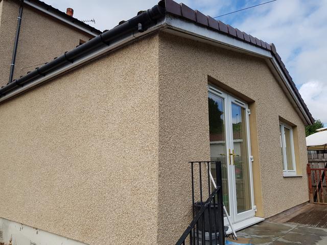 Beige roughcast on a single-storey extension