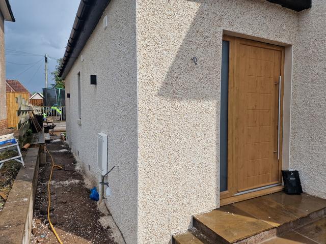 Cream dry dash beside a new oak front door