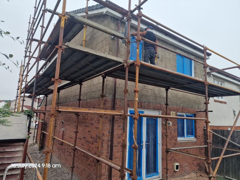 Gable stripped back to bare blockwork with scaffold up and beads being fixed