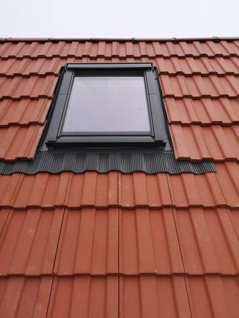Rooflight fitted with its proper manufacturer flashing kit, dressed into the surrounding tiles