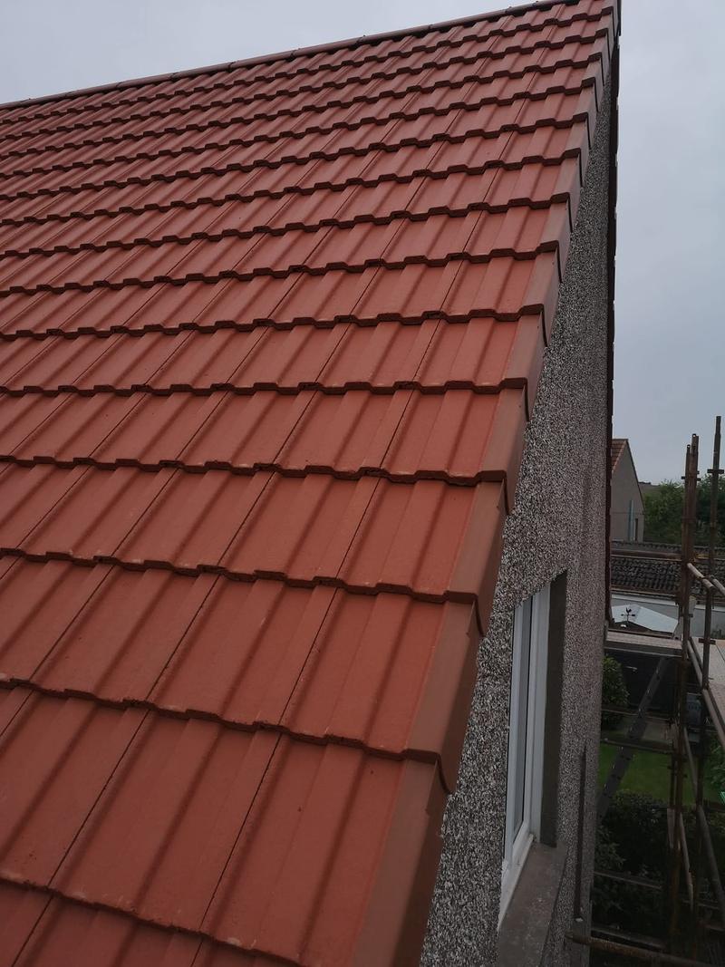 Verge tiles finished cleanly over the roughcast gable wall