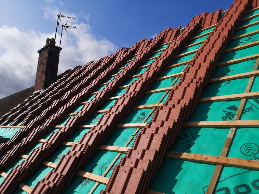 New concrete tiles loaded out in courses across the battened roof